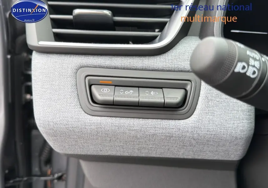 Détail des commandes d’éclairage sur tableau de bord gris clair d’une Renault Clio V 1.0 TCe 90 essence.