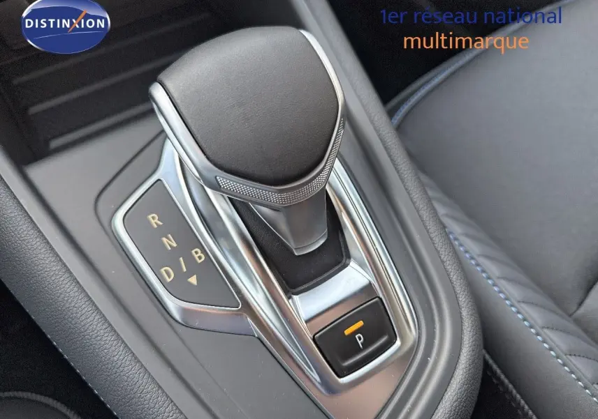 Gros plan sur la commande de boîte automatique noire et chrome du Renault Symbioz gris cassiopée métal, intérieur cuir noir.