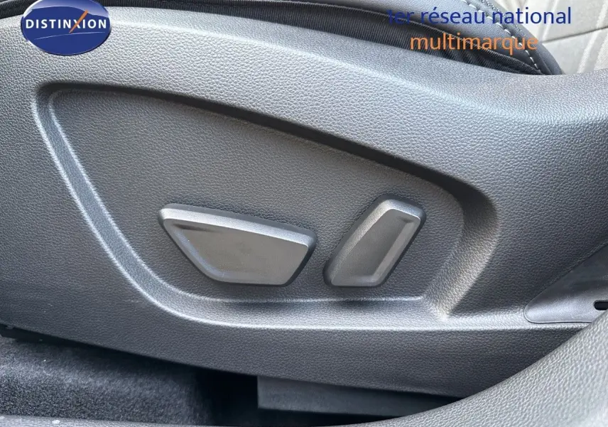 Gros plan sur les commandes électriques du siège avant d'une Renault Symbioz gris cassiopée métal, version hybride 2024.