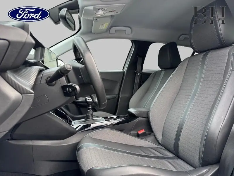 Intérieur avant du Peugeot 2008 1.5 BlueHDi 2021 avec sièges tissu gris et volant multifonction visible côté conducteur