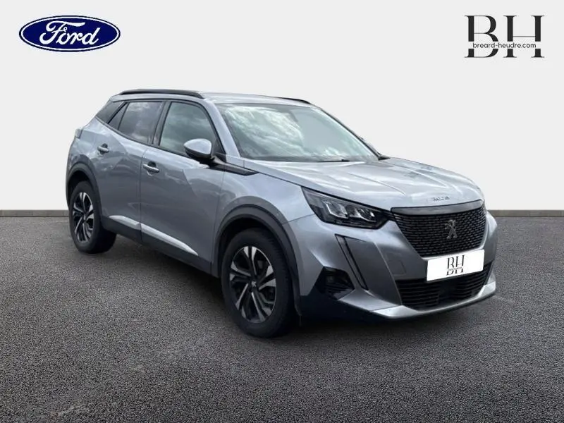 Peugeot 2008 gris Artense vue 3/4 avant droit, soulignant sa calandre noire et ses jantes alu distinctives.