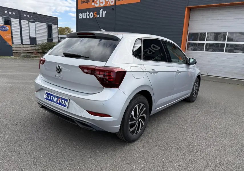 Volkswagen Polo gris Reflet Argent vue 3/4 arrière droit, vitres surteintées et jantes noires bicolores.