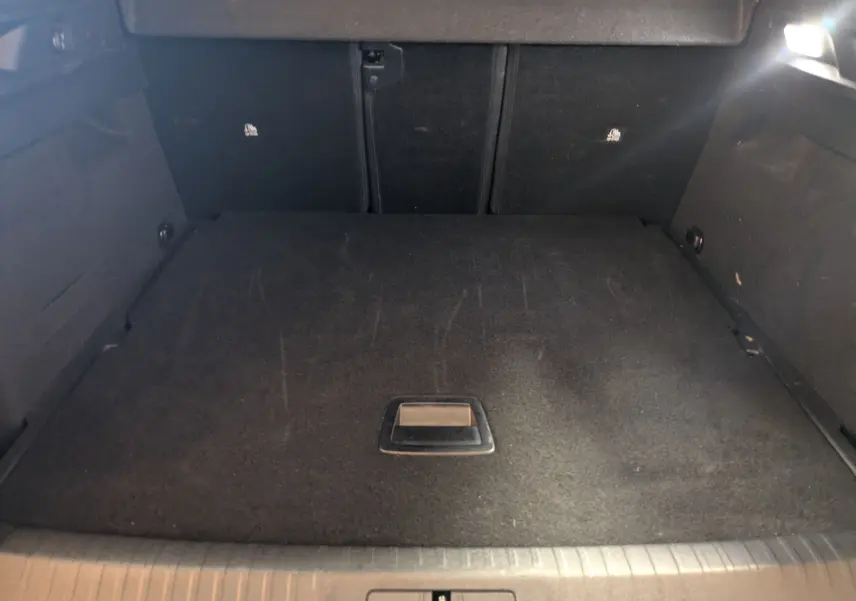Vue intérieure du coffre noir du Peugeot 3008 Hybrid 145 e-DCS6 Allure 2025, espace de chargement propre et spacieux.
