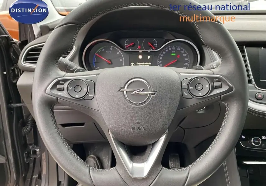 Volant en cuir noir de l'Opel Grandland X hybride 2021 avec commandes intégrées et tableau de bord visible.