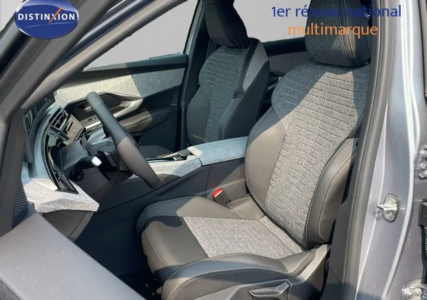 Intérieur avant droit du Peugeot 3008 Hybrid 2025 gris Artense, sièges tissu et cuir noir avec console centrale assortie.
