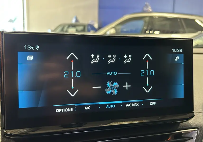 Écran tactile du système de climatisation automatique du Peugeot 5008 gris Platinium, affichant 21°C en mode auto.