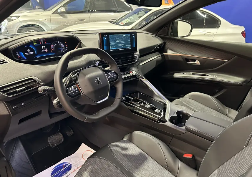 Intérieur du Peugeot 5008 2024, vue côté conducteur, tableau de bord moderne et sièges en cuir gris.