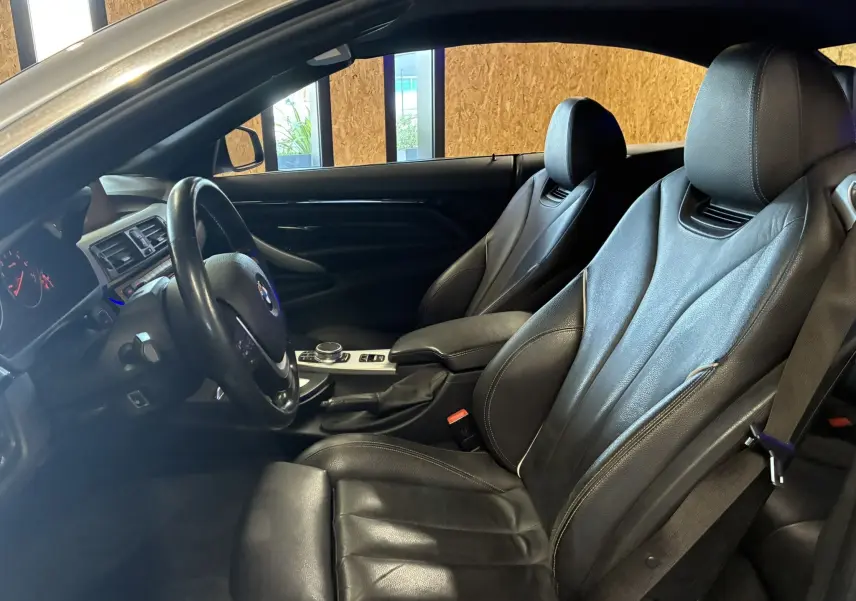 Intérieur noir en cuir de la BMW Série 4 Cabriolet 420i 2019, vue côté conducteur avec volant et sièges chauffants visibles.