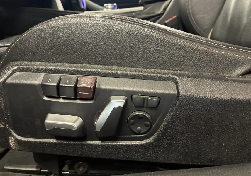 Gros plan sur les commandes de réglage électrique du siège en cuir noir d'une BMW Série 4 Cabriolet gris 2019.
