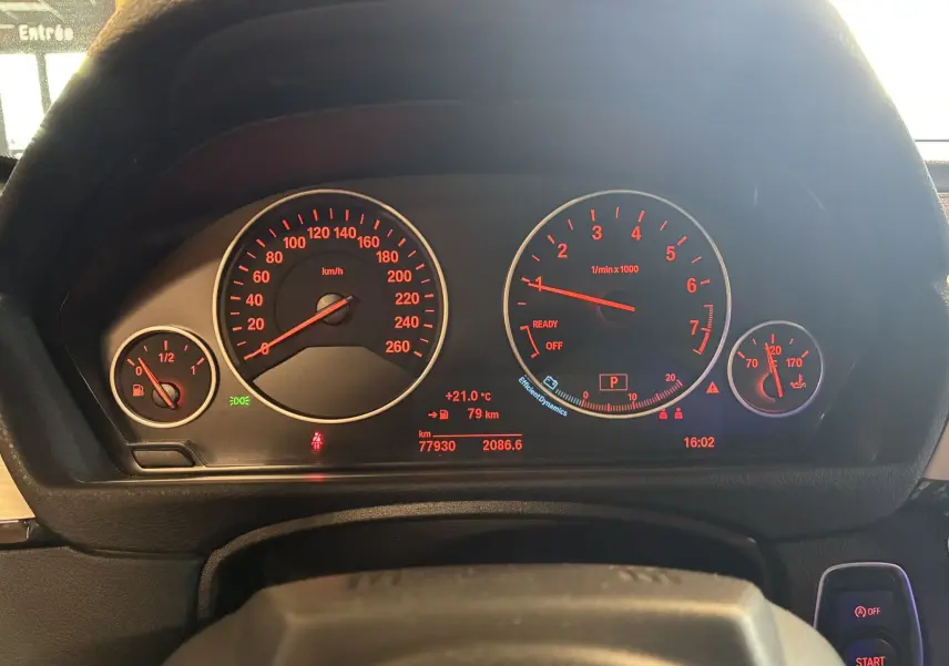 Tableau de bord éclairé en rouge de la BMW Série 4 Cabriolet gris, affichant vitesse, compte-tours et jauge carburant.