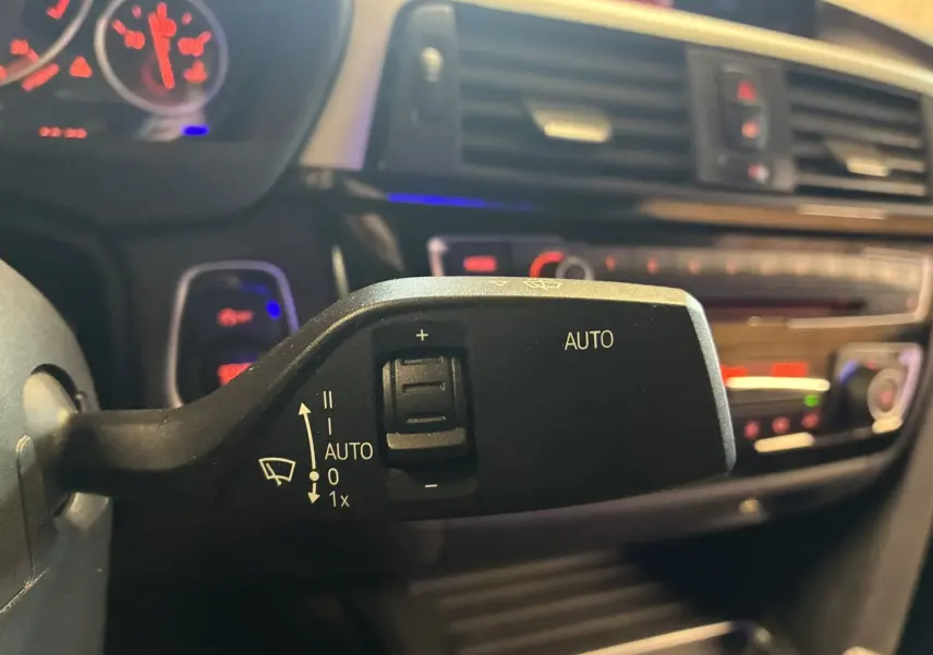 Gros plan sur la commande d'essuie-glace automatique dans l'habitacle noir d'une BMW Série 4 Cabriolet gris 2019.