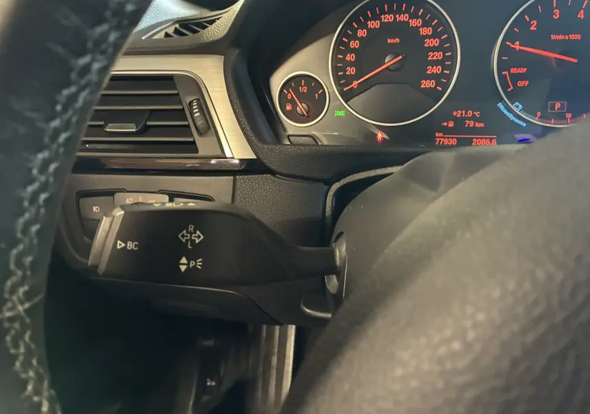 Vue rapprochée du tableau de bord noir et du compteur rouge d'une BMW Série 4 Cabriolet F33 gris, 2019.