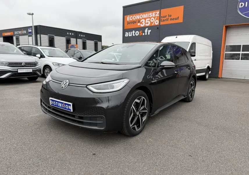 Volkswagen ID.3 Pro S gris manganèse vue 3/4 avant droit sur parking devant un bâtiment commercial