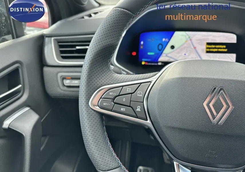 Gros plan sur le volant perforé et les commandes à gauche du tableau de bord d'une Renault Symbioz noir étoile métal.