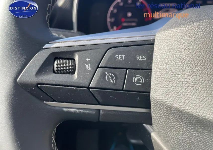 Gros plan sur les commandes de régulateur de vitesse au volant gris d'une SEAT LEON IV 2.0 TDI 115CH STYLE PACK 2024.