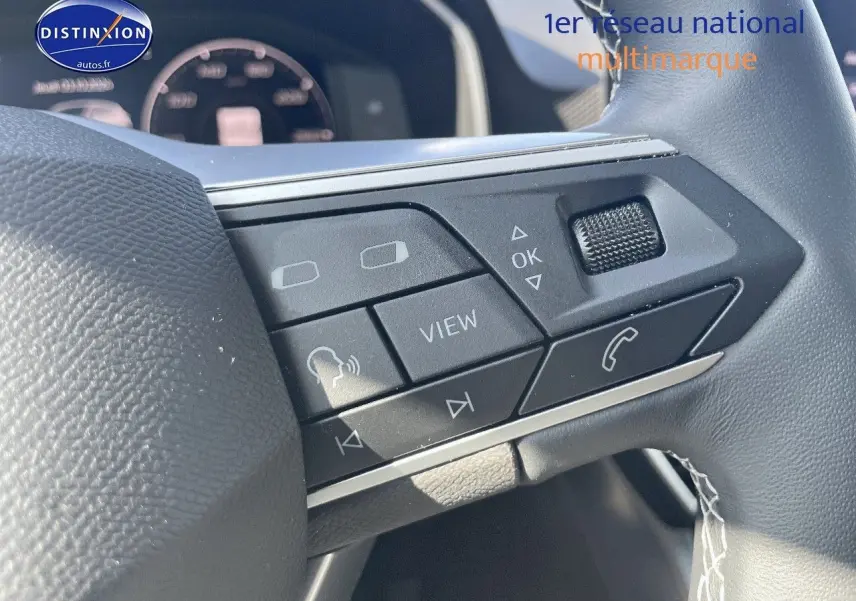 Gros plan sur les commandes multifonctions à droite du volant en cuir gris du SEAT Leon IV gris magnétique 2024.