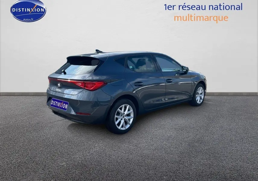 SEAT Leon IV gris magnétique métal vue 3/4 arrière côté droit, soulignant ses lignes modernes et jantes argentées.