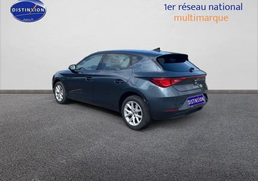 Vue 3/4 arrière droite d'une SEAT Leon IV gris magnétique métallisé avec jantes alliage et feux arrière LED.