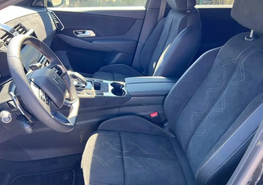 Intérieur du DS7 2025 en gris titane, vue côté conducteur montrant sièges en alcantara et volant multifonction.