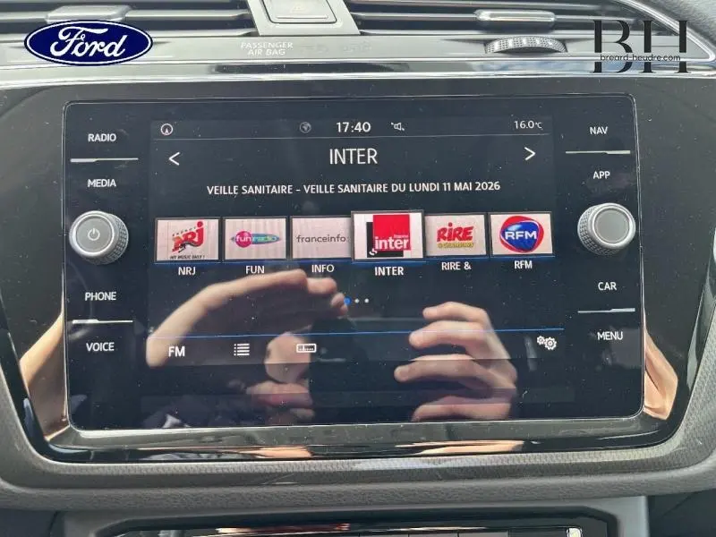 Écran tactile central du Volkswagen Touran 2020 en gros plan, affichant les stations radio FM avec cadre noir brillant.