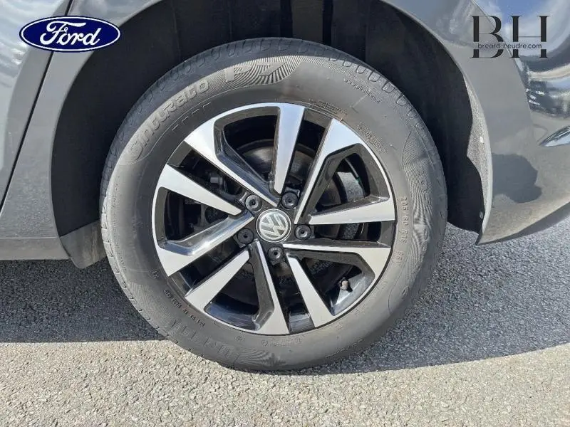 Gros plan sur la roue avant droite avec jante alliage bicolore du Volkswagen Touran gris Urano.