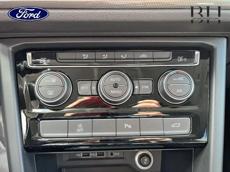 Détail de la console centrale noire du Volkswagen Touran 2020 avec commandes de climatisation et boutons multifonctions.
