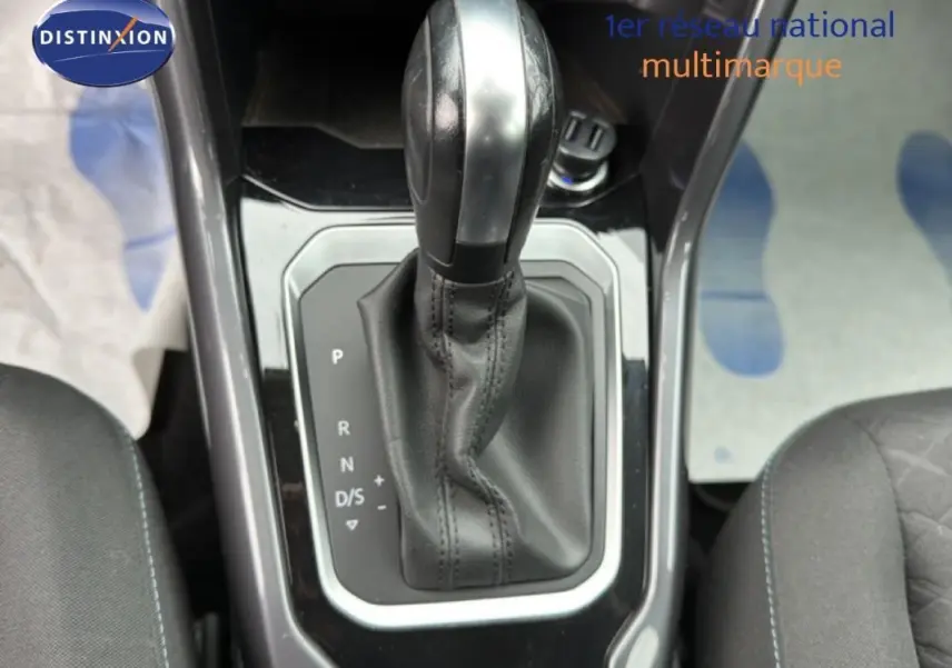 Gros plan sur le levier de vitesse automatique noir du Volkswagen T-Roc 2020, entouré des sièges avant gris foncé.