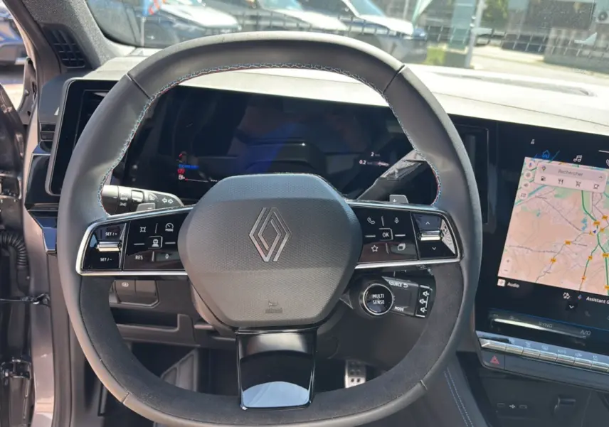 Vue rapprochée du volant multifonction du Renault Austral E-Tech 200 Esprit Alpine 2025 avec tableau de bord numérique et écran tactile.