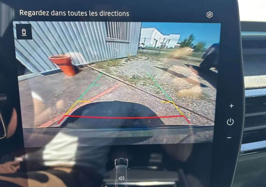 Vue caméra de recul du Renault Austral E-Tech 200 Esprit Alpine gris schiste avec toit noir, montrant l'arrière du véhicule et l'environnement immédiat.