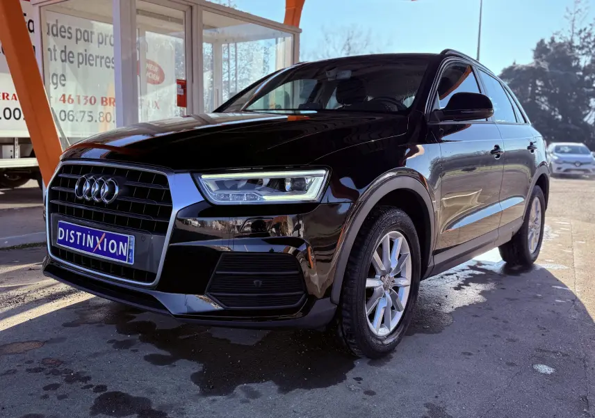 Audi Q3 noir en 3/4 avant droit, mettant en valeur ses phares LED et la calandre distinctive.