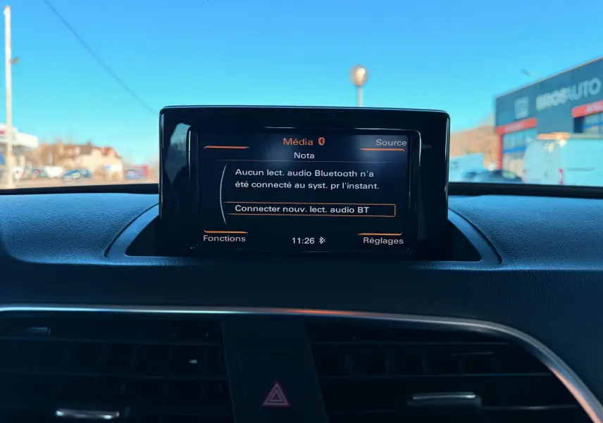 Écran central du tableau de bord de l'Audi Q3 2016 affichant le menu média Bluetooth, vue intérieure frontale.