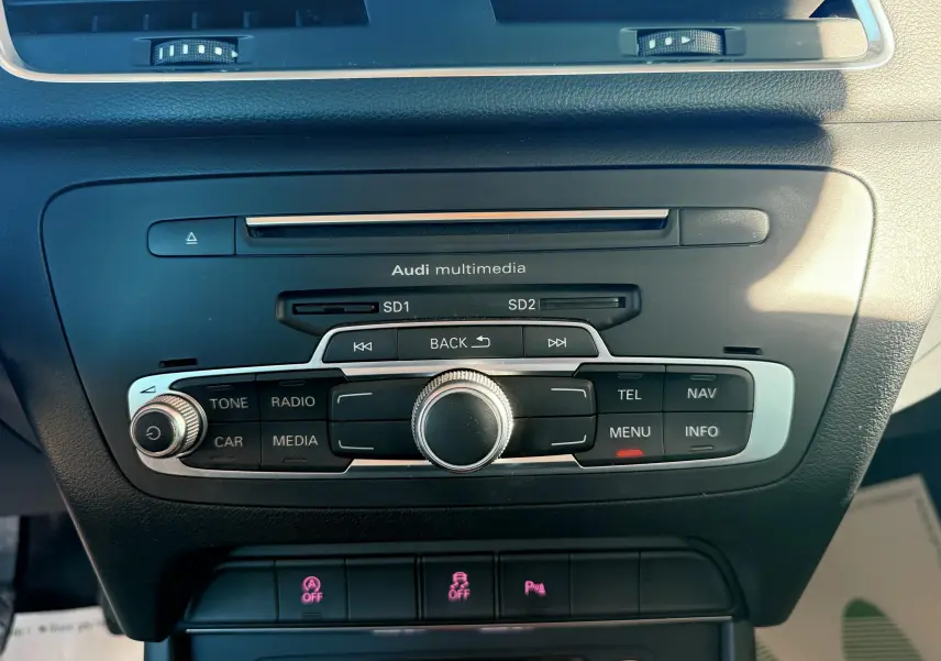 Gros plan sur la console centrale noire de l'Audi Q3 2016 avec commandes multimédia et climatisation.