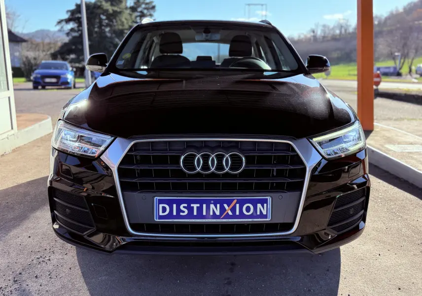 Vue avant d’un Audi Q3 noir 2016 avec calandre chromée et phares LED allumés sous un abri extérieur.