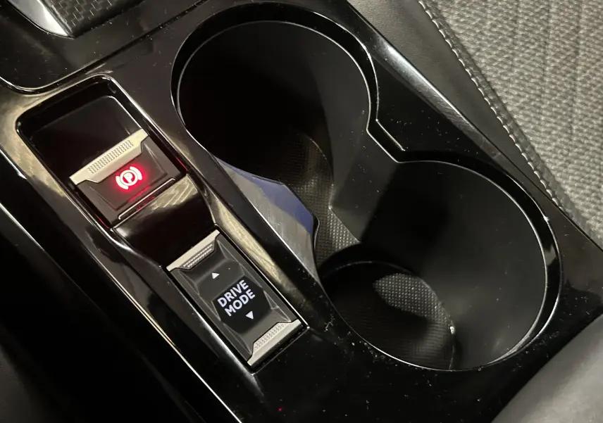 Vue rapprochée de la console centrale noire avec bouton frein à main électronique et sélection du mode de conduite Peugeot 2008.