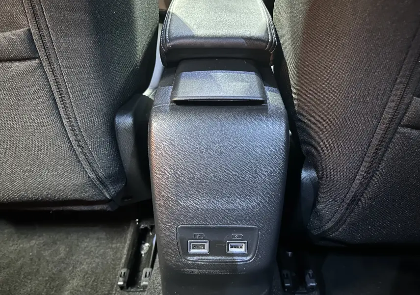 Prise USB double en bas de la console centrale arrière entre les sièges noirs du Peugeot 2008 bleu Obsession.