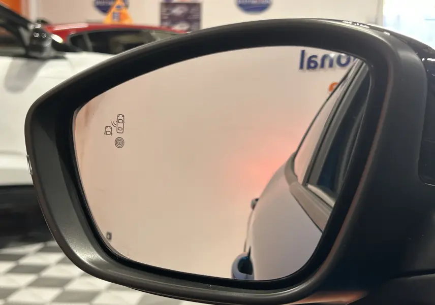 Rétroviseur côté gauche de la Peugeot 2008 Bleu Obsession, vue rapprochée avec affichage de l'alerte angle mort.