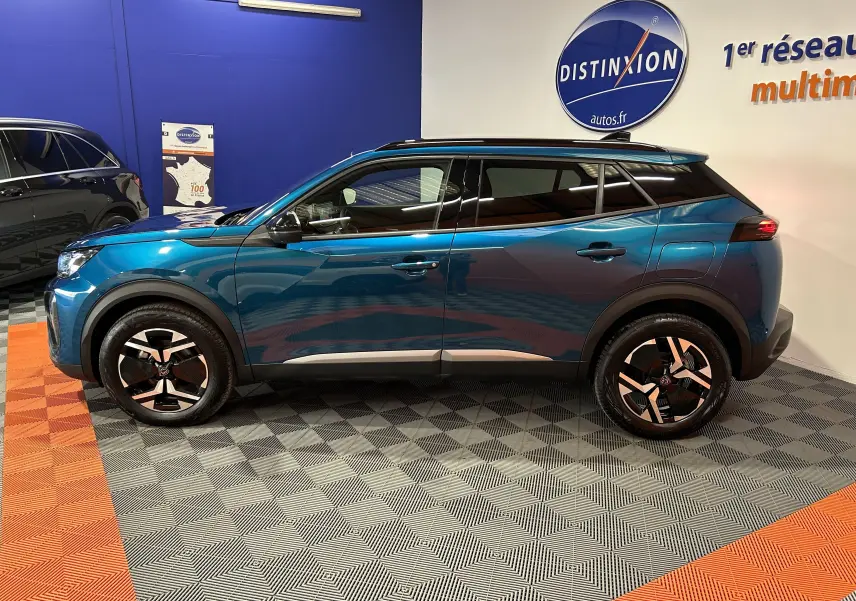 Peugeot 2008 II Ph.2 Allure Hybrid bleu Obsession vue de profil côté gauche en intérieur showroom.