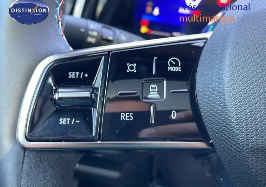 Gros plan sur les commandes de régulateur de vitesse au volant du Renault Espace blanc nacré 2025 hybride.