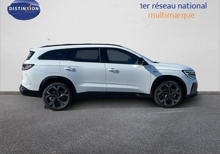 Profil côté droit du Renault Espace 2025 blanc nacré, SUV hybride avec jantes noires et toit panoramique.