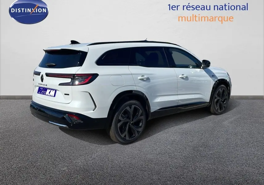 Vue 3/4 arrière droite d'un Renault Espace blanc nacré 2025 avec jantes noires et feux arrière LED allumés.