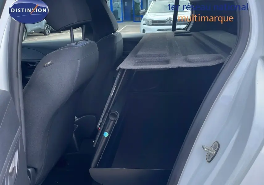 Intérieur arrière côté droit d'une Peugeot 208 blanc banquise 2021 avec banquette rabattue et sellerie noire.