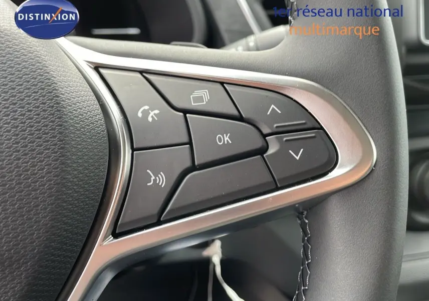 Gros plan sur les commandes multifonctions du volant en cuir noir du Renault Trafic Fourgon blanc glacier 2025.