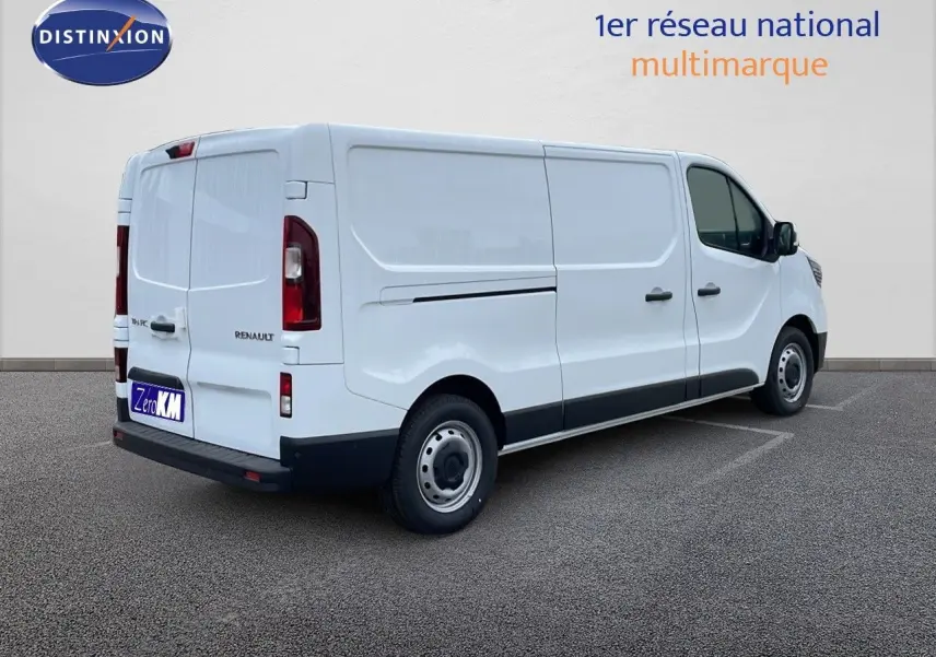 Renault Trafic Fourgon blanc glacier vu en 3/4 arrière côté droit, avec portes latérales et feux arrière visibles.
