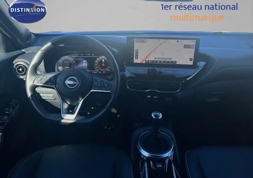 Vue intérieure avant du Nissan Juke 2025 bleu magnétique, avec tableau de bord numérique et écran tactile central.