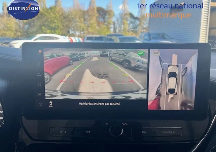 Vue intérieure sur l’écran multimédia affichant la caméra de recul et la vue 360° du Nissan Juke bleu magnétique.
