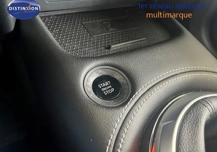 Bouton start/stop moteur en gros plan sur la console centrale en cuir noir du Nissan Juke 2025.