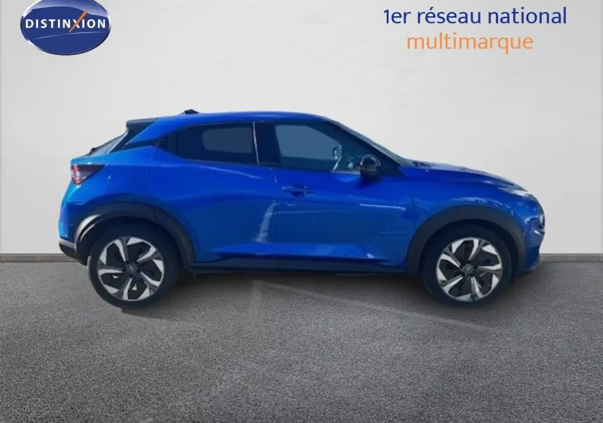 Vue de profil côté gauche d'un Nissan Juke 2025 bleu magnétique métallisé avec jantes distinctives et toit noir.