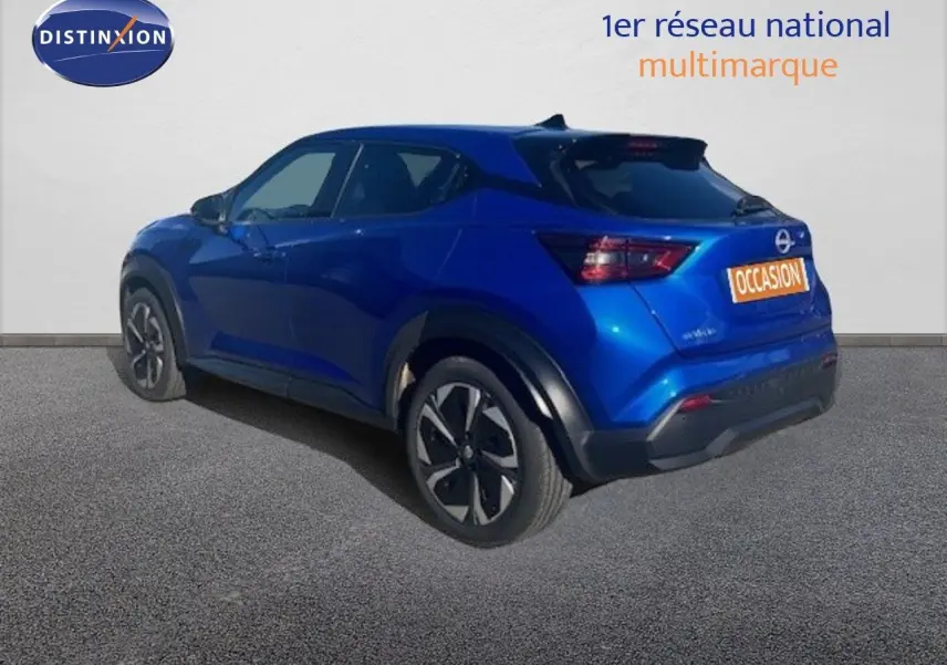 Nissan Juke bleu magnétique métal vu en 3/4 arrière côté gauche, avec jantes noires et détails noirs contrastants.