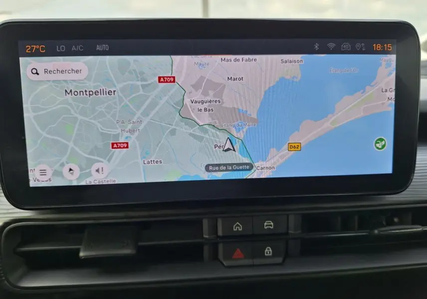 Écran tactile intérieur montrant la navigation GPS avec carte de Montpellier, boutons de commande en dessous.