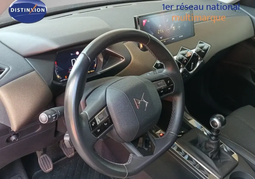 Vue intérieure du poste de conduite du DS3 Crossback avec volant cuir, tableau de bord numérique et levier de vitesses manuel.